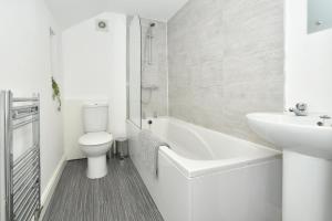 uma casa de banho branca com um WC e um lavatório em Victoria House by YourStays, City Centre, free parking, sleeps 6 em Stoke-on-Trent