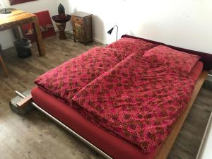 Bel Art Etage في هان: بطانية حمراء ملقاة فوق السرير
