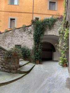 een stenen tunnel met planten die aan de zijkant van een gebouw groeien bij Saffi58 Holiday Home in Viterbo