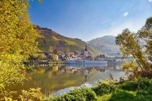 a view of a lake with a church and a hill at Luxus Apartments Mosel-Zeit NEU 2023 in Zell an der Mosel
