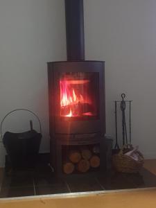 a wood stove with a fire in a room at A Stanthorpe Getaway in Ballandean