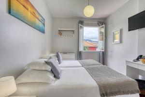 Habitación blanca con cama y ventana en Vila Camacho Guest House, en Funchal