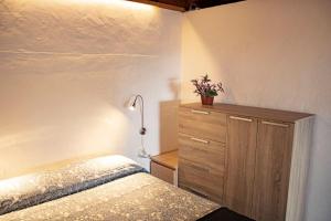 a bedroom with a bed and a dresser with a plant on it at El Sueño: un lugar especial para sus vacaciones in Fuencaliente de la Palma