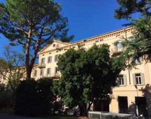 een groot wit gebouw met bomen ervoor bij Walters Balcony Suite in Lugano