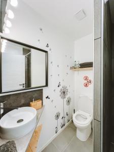 une salle de bain avec un lavabo, des toilettes et un miroir dans l'établissement Séjour pro & Famille - Gîtes meublés Wood Sky - WIFI Parking privé Terrasses & Jardin, à Laveyron 25 autres photos