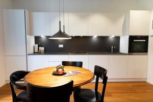 cocina con mesa de madera y sillas negras en Walters Balcony Suite en Lugano