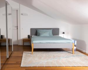 a bedroom with a bed with a rug and a mirror at Walters Balcony Suite in Lugano