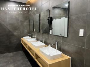 Baño con 2 lavabos y espejo en Hasu The Hotel, en Rạch Giá
