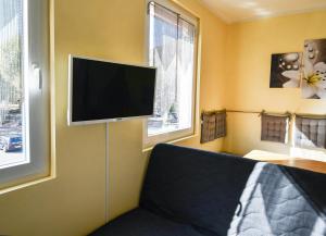 sala de estar con TV de pantalla plana en la pared en Historia Hotel, en Neustadt an der Weinstraße