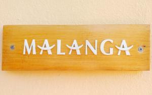 ein Schild mit dem Wort Muzong an der Wand in der Unterkunft Studio Malacca et Malanga- Ô Cœur de Deshaies in Deshaies