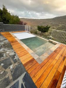 a swimming pool on a deck with a wooden floor at Gites en Ardèche avec Piscine et vue magnifique sur la vallée in Rochessauve
