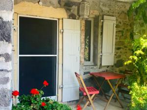 une table et une chaise devant le bâtiment dans l'établissement Gites en Ardèche avec Piscine et vue magnifique sur la vallée, à Rochessauve