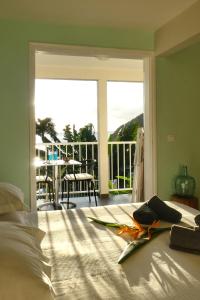 - une chambre avec un lit et un balcon dans l'établissement Studio Malacca et Malanga- Ô Cœur de Deshaies, à Deshaies