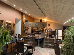 a large kitchen with a table and chairs in a room at Hôtel *** Les Tremplins in La Chaux Neuve