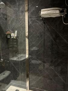 a bathroom with a glass shower with a sink at فندق النزيل الذهبي - Golden Guest Hotel in Jazan