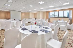 una sala de conferencias con mesas blancas y sillas blancas en Makarem Al Bait Al Azizia Hotel, en La Meca