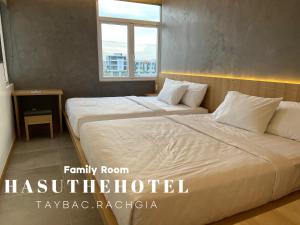 a bedroom with two beds and a window at Hasu The Hotel - Rach Gia in Rạch Giá