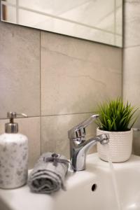 Un lavabo de baño con grifo y espejo. en Luxor Apartment, en Velingrad 51 fotos más