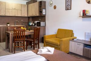 uma cozinha e sala de estar com mesa e cadeiras em Luxor Apartment em Velingrad