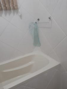 a white bathroom with a tub and a towel at Apartamento 2 dormitórios, wifi, ponta da praia, predio em frente ao mar - Santos in Santos