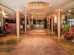 a hallway with a large rug and chandeliers at Falkensteiner Hotel Bratislava in Bratislava