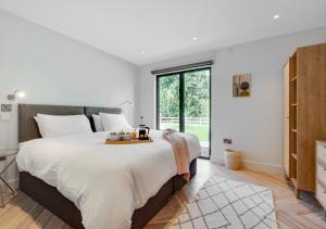 a bedroom with a large bed and a large window at Daisys Barn in Mattishall