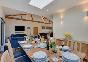 a dining room and living room with a wooden table at Daisys Barn in Mattishall