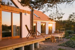 a house with a wooden deck with a table and chairs at Nature Home Rybical in Rybical