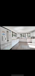 a large kitchen with white counters and appliances at Beautiful mansion in private gated Rd Hot tub FREE SAUNA in Luton