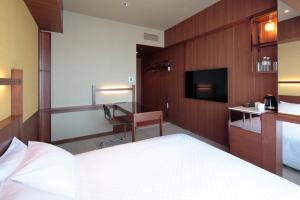 Habitación de hotel con cama y escritorio en Candeo Hotel Utsunomiya en Utsunomiya