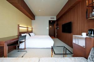 Habitación de hotel con cama y escritorio en Candeo Hotel Utsunomiya en Utsunomiya