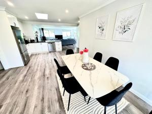 een keuken en eetkamer met een tafel en stoelen bij Relaxing 3 bedroom house with 2 bathrooms. in Katoomba