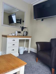 a room with a desk with a mirror and a chair at Four Seasons Hotel in Aberystwyth