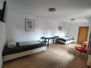a bedroom with two beds and a table and chairs at Apartment für Monteure in Halle (Saale) Mitte in Halle an der Saale