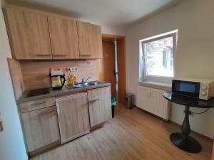 a kitchen with wooden cabinets and a sink and a window at Apartment für Monteure in Halle (Saale) Mitte in Halle an der Saale