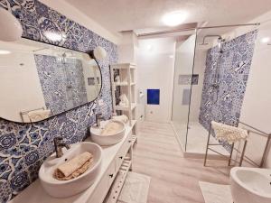 un bagno blu e bianco con due lavandini e una doccia di Holiday Home Virgilio House a Cagliari