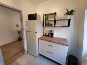 kuchnia z białą lodówką i kuchenką mikrofalową w obiekcie Chaleureux 2 pièces au centre de Haguenau w mieście Haguenau +3 zdjęcia