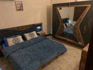 a bedroom with a bed and a large mirror at Dreams Apartments شقق الاحلام in Baghdad