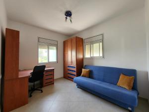 sala de estar con sofá azul y escritorio en Shturman Apartment Haifa, en Haifa