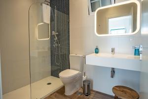 a bathroom with a toilet and a sink and a shower at Feel Nazaré - Abegoarias 62 in Nazaré +13 photos