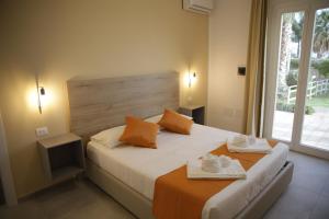 Oasi Guzzetta Hotel في مارسالا: غرفة نوم عليها سرير وفوط