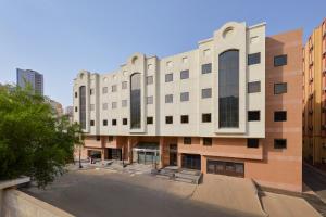 un gran edificio con un estacionamiento delante de él en Makarem Mina Hotel, en La Meca