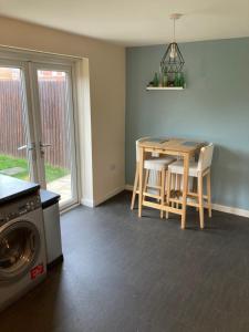 a kitchen with a table and a washing machine at Cheerful Home FOR FOOTBALL, DOCKS AND CITY CENTRE in Liverpool