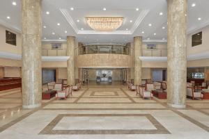 - un hall d'un hôtel avec des chaises et un lustre dans l'établissement Makarem Mina Hotel, à La Mecque