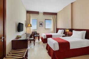 Cette chambre comprend deux lits et une télévision. dans l'établissement Makarem Mina Hotel, à La Mecque