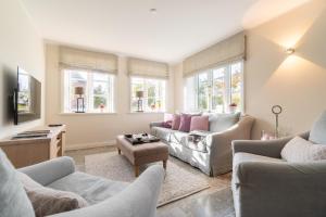 a living room with couches and chairs and windows at Reethus Westerheide in Nieblum