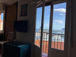 a door with a view of the ocean from a balcony at IZARO EYE Bermeo in Bermeo