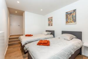 2 camas en una habitación con paredes blancas en Duinenrij 197, en Bredene