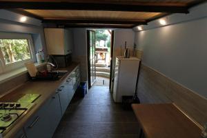 a kitchen with a refrigerator and a wooden floor at domek letniskowy Majdy własna plaża in Majdy