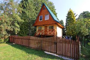 una pequeña casa con una valla delante de ella en domek letniskowy Majdy własna plaża, en Majdy